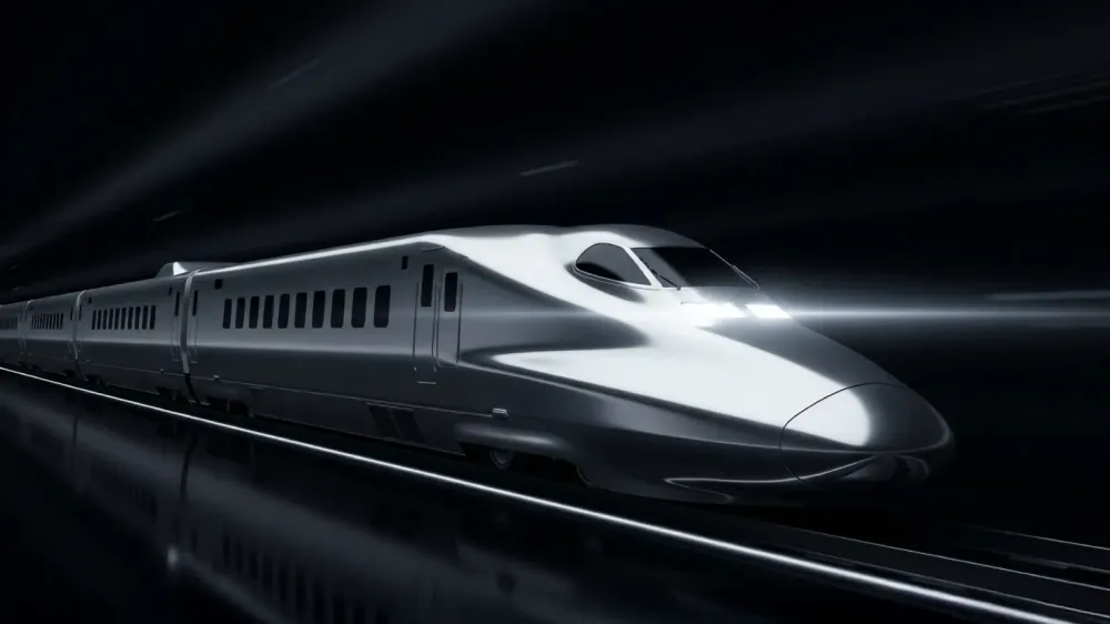 A sleek silver high-speed train moving rapidly through a dark tunnel with bright headlights illuminating the track ahead.