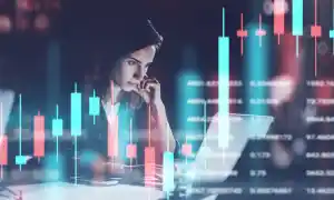 An online trader studying trading charts on her laptop