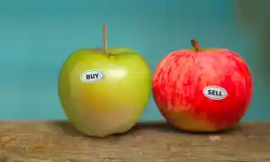 two apples with 'buy' and 'sell' sticker on it